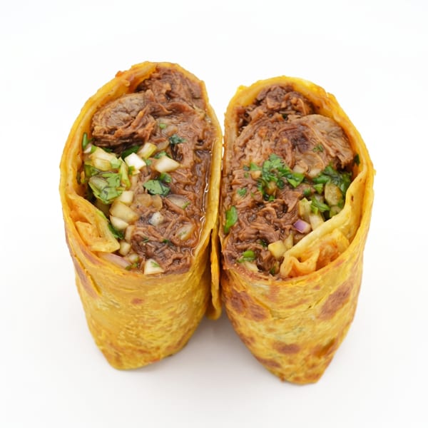 Two halves of a golden burrito filled with shredded beef, diced onions, and cilantro.