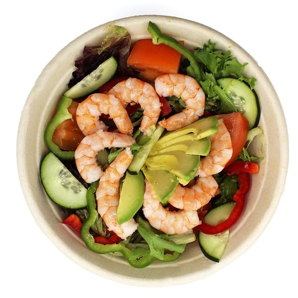 Shrimp salad with avocado, cucumber, bell peppers, and mixed greens in a bowl.